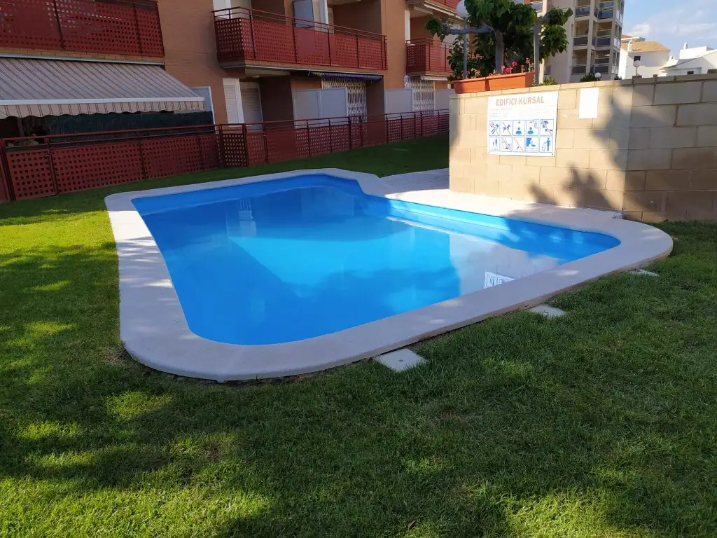 Piscina comunitaria con césped